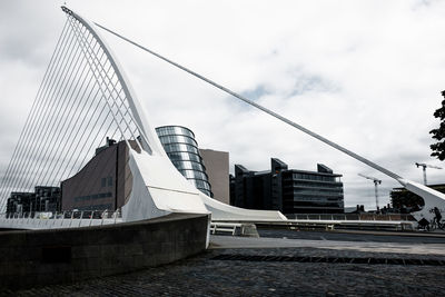 Modern cityscape by river against sky
