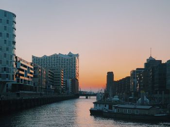 View of river and buildings against clear sky