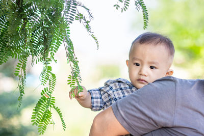 Portrait of cute baby against trees