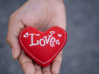 Midsection of person holding heart shape with text