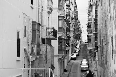 Man working on alley amidst buildings in city