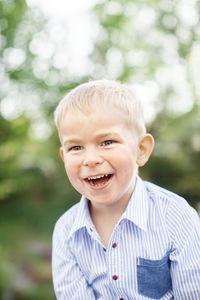 A boy laughing, outdoors