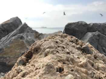 Rock formation on beach against sky