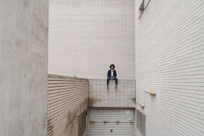 Male entrepreneur sitting on retaining wall