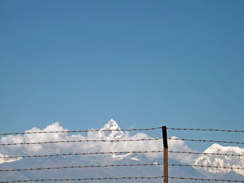 Low angle view of snow against clear blue sky