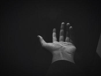 Close-up of hand against black background