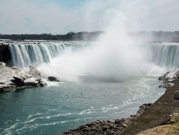 Scenic view of waterfall against sky