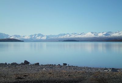 Scenic view of lake against clear blue sky