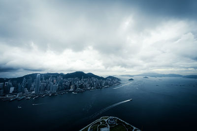 Aerial view of city by sea against sky