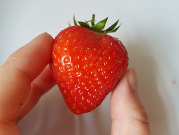 Close-up of hand holding strawberry