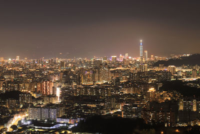 Illuminated cityscape against sky at night