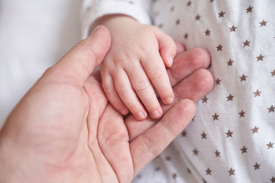 Mothers hand holding baby hand. the baby is one month old. cute little hand with small fingers. 