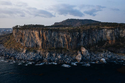 Rock formations in sea against sky