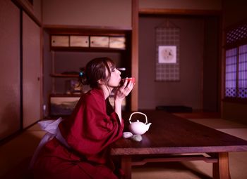 Woman drinking coffee cup on table at home