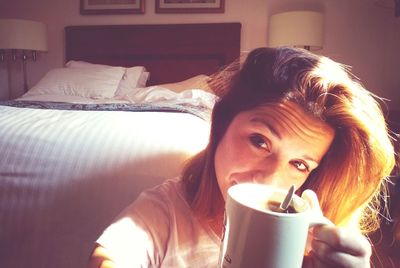 Close-up portrait of young woman drinking coffee