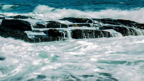 Water splashing on rocks in sea 