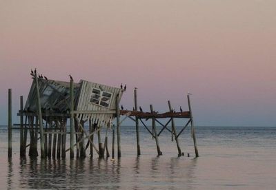 Pier on sea at sunset