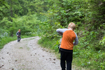 Rear view of two boys walking in forest