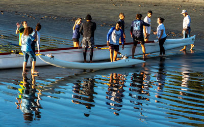 People standing on boats moored in sea