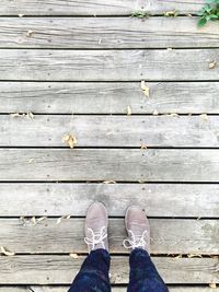 Low section of brown shoes with a person  standing on wood