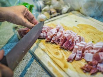 Cropped image of person preparing food on cutting board