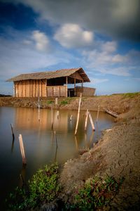 Built structure by lake against sky