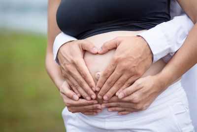 Midsection of couple holding hands