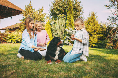 Cute girl sitting with dog at lawn