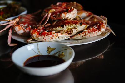 Close-up of sauce and crabs on table