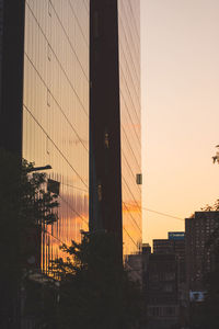 Low angle view of modern buildings against sky during sunset
