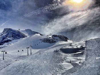 Scenic view of snow covered mountains against cloudy sky