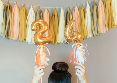 Cropped hands of woman holding number 24 decorations