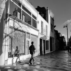 People walking on street amidst buildings in city