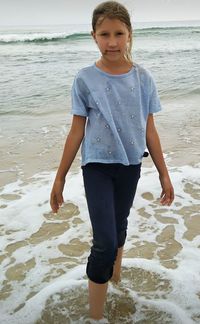 Full length portrait of girl standing on beach