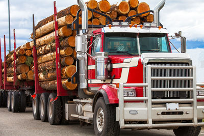 Red truck with logs on road