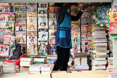 Woman arranging magazines in store