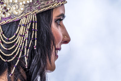 Close-up of young woman wearing headwear against sky