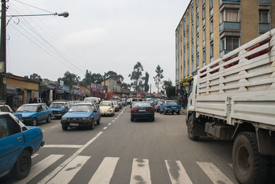 Cars on road in city against sky