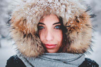 Close-up portrait of young woman in snow