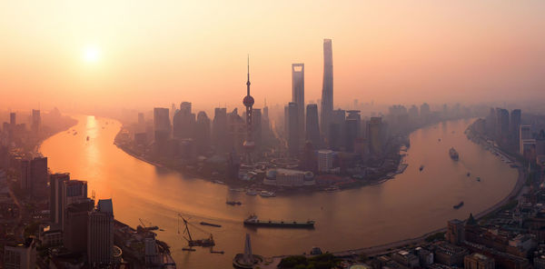 Aerial view of buildings in city during sunset