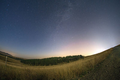 Scenic view of field against clear sky at night