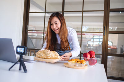 Portrait of smiling woman with food on table