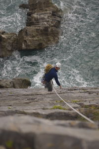 Man standing on rock against waterfall