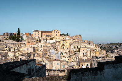 Old buildings in city against clear blue sky