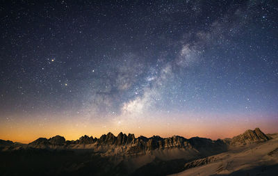 Scenic view of snowcapped mountains against sky at night