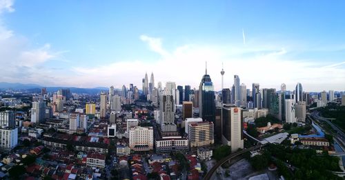 View of cityscape against cloudy sky