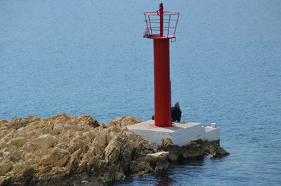 Man sitting by lighthouse