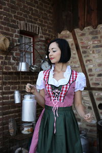 Young woman holding container while standing at home