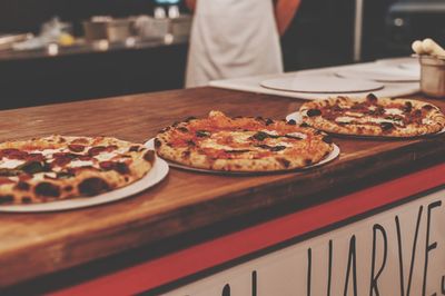 Man preparing pizza on table in restaurant