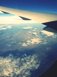 Cropped image of airplane wing over landscape